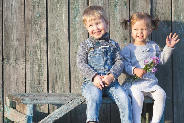 Niños felices al aire libre en temporada de otoño, sentados en el banco. Primera cita —  Fotos de Stock