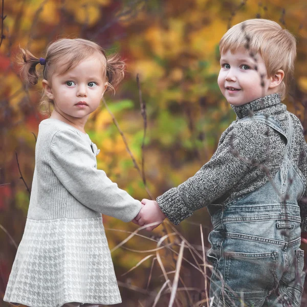 Joyeux enfants en plein air à la saison d'automne, se tenant la main. A date — Photo