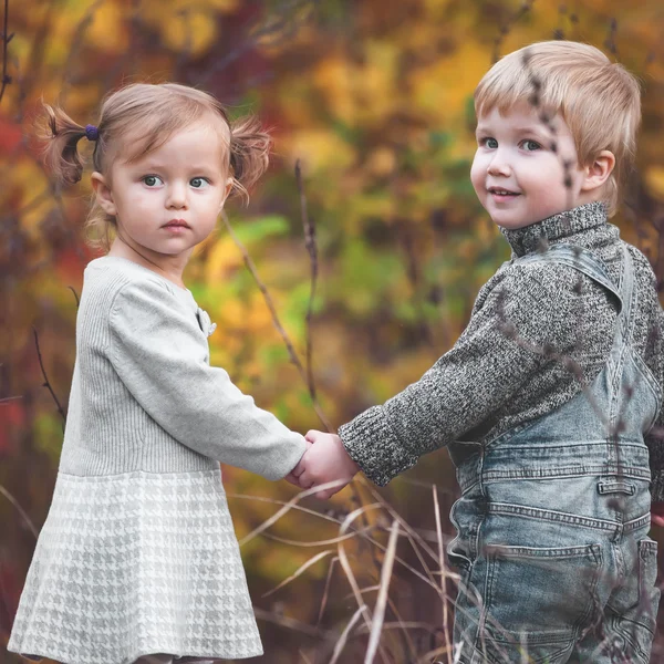 Niños felices al aire libre en temporada de otoño, tomados de la mano. Tiene fecha —  Fotos de Stock