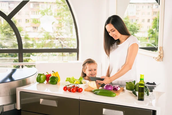 Söt liten flicka matlagning med mamman på kök — Stockfoto