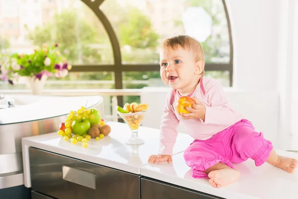 Bayi lucu di dapur memegang buah persik — Stok Foto