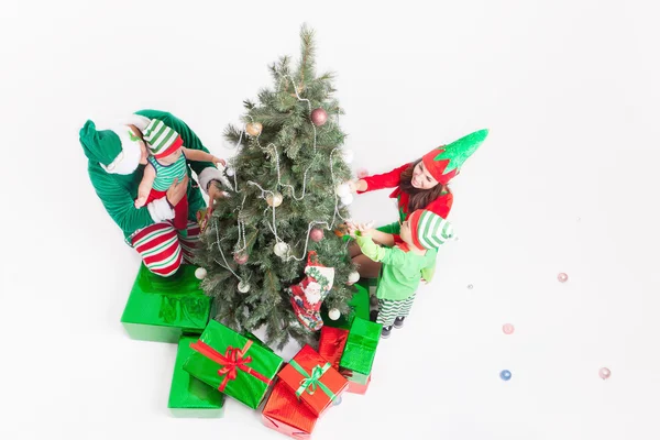 Ευτυχισμένη οικογένεια διακόσμηση του Χριστουγεννιάτικου δέντρου, ντυμένοι με στολές ξωτικό — Φωτογραφία Αρχείου