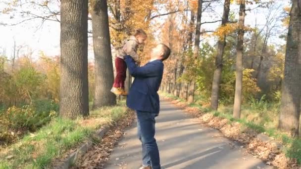 Vater wirft Baby ins Freie. Herbstwald. glückliche Familienwerte — Stockvideo
