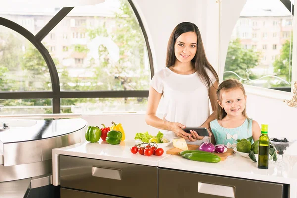 Söt liten flicka matlagning med mamman på kök — Stockfoto