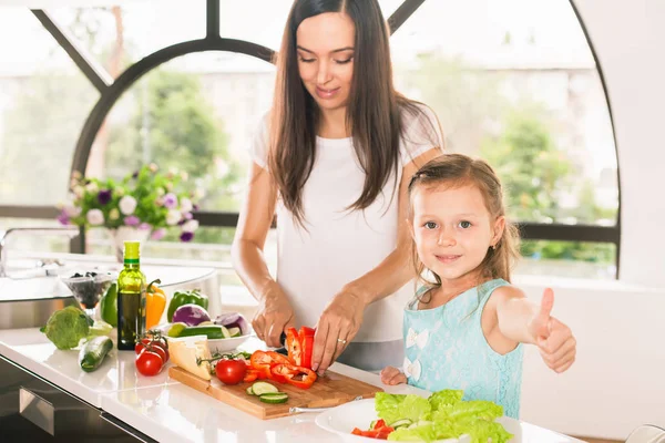 Söt liten flicka matlagning med mamman på kök — Stockfoto