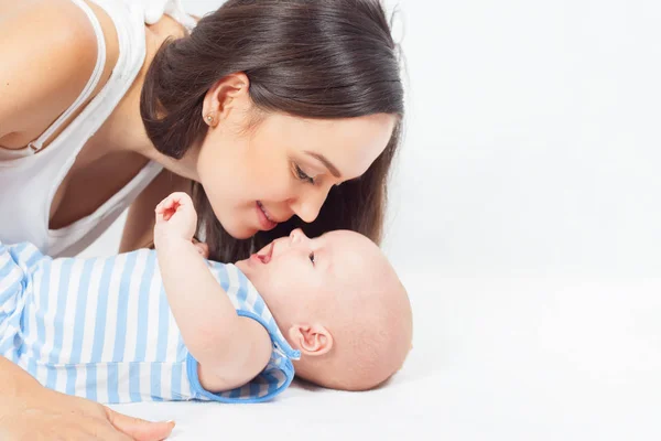 Mãe feliz segurando um menino no fundo branco — Fotografia de Stock