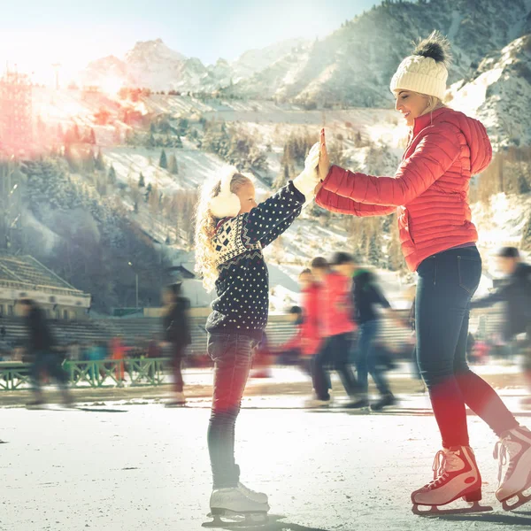 Felice famiglia pattinaggio sul ghiaccio all'aperto alla pista di pattinaggio. Attività invernali — Foto Stock