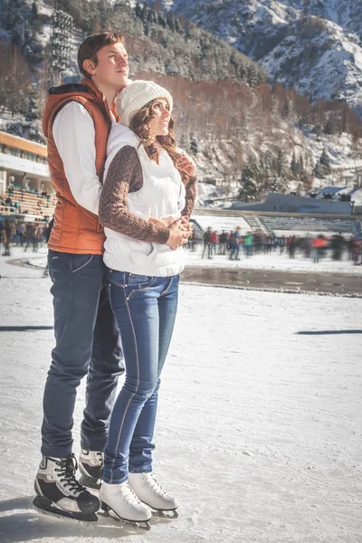 Coppia, ragazze e ragazzo pattinaggio su ghiaccio all'aperto alla pista di pattinaggio — Foto Stock