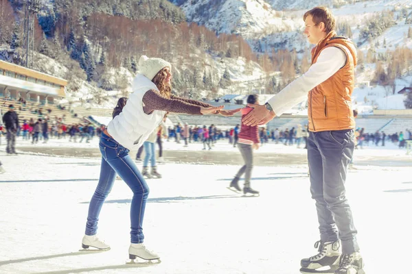 Gelukkige paar, meisjes en jongen schaatsen buiten op ijsbaan — Stockfoto