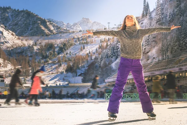 Chica latina patinaje sobre hielo al aire libre en pista de patinaje. Estilo de vida saludable —  Fotos de Stock