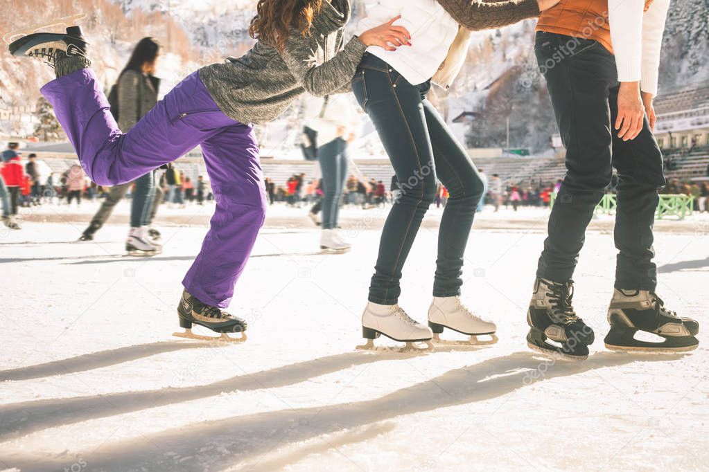 Funny teenagers girls and boy skating outdoor, ice rink