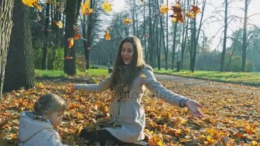 Anne bebekle oynarken açık bırakır. Sonbahar orman, park.