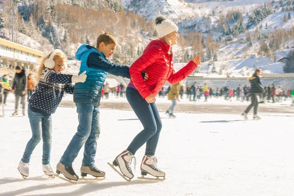 Feliz família de patinação no gelo ao ar livre no ringue. Actividades de Inverno — Fotografia de Stock