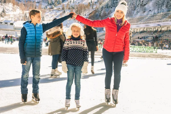 Feliz família de patinação no gelo ao ar livre no ringue. Actividades de Inverno — Fotografia de Stock