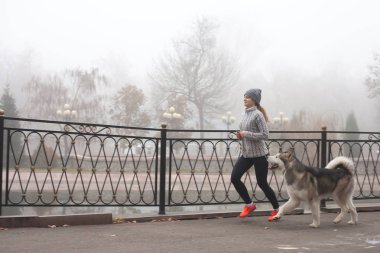 Köpeğini, alaskan malamute koşan genç kız resim
