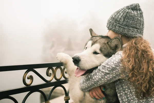 Bilden av ung flicka med hennes hund, alaskan malamute, Utomhus — Stockfoto