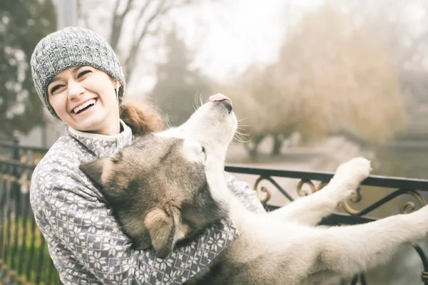 Bilden av ung flicka med hennes hund, alaskan malamute, Utomhus — Stockfoto