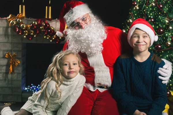 Ευτυχισμένο τον Άγιο Βασίλη και τα παιδιά γύρω από το στολισμένο χριστουγεννιάτικο δέντρο — Φωτογραφία Αρχείου