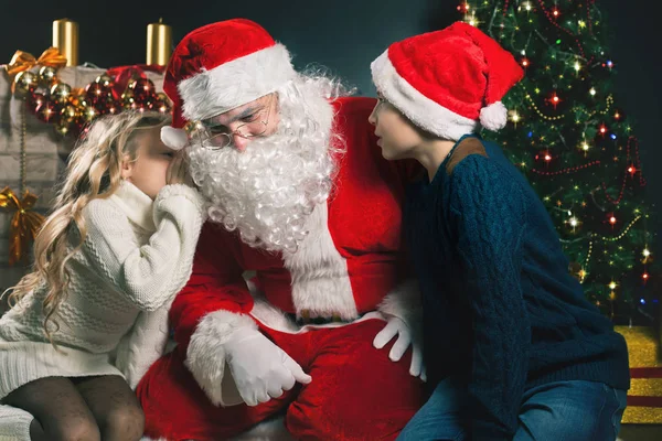 Papai Noel e crianças ao redor da árvore de Natal decorada. Lista de desejos — Fotografia de Stock