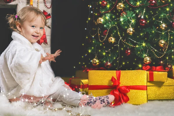 Menina bonito jogando perto de lareira e árvore de Natal decorado — Fotografia de Stock