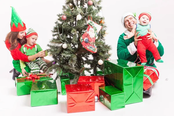 Feliz familia decorando el árbol de Navidad, vestido con trajes de elfo —  Fotos de Stock