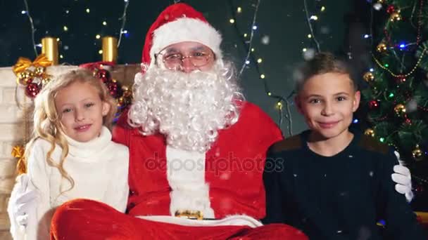 Santa y los niños cerca del árbol de Navidad decorado. Lista de deseos — Vídeos de Stock