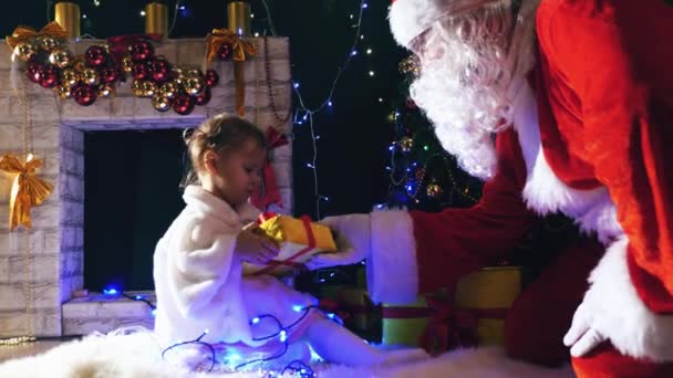 Père Noël donne une boîte cadeau à mignonne petite fille, Noël — Video