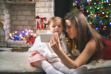 Bir Noel ağacı süsleme şirin bebek kız. Kırmızı topları.