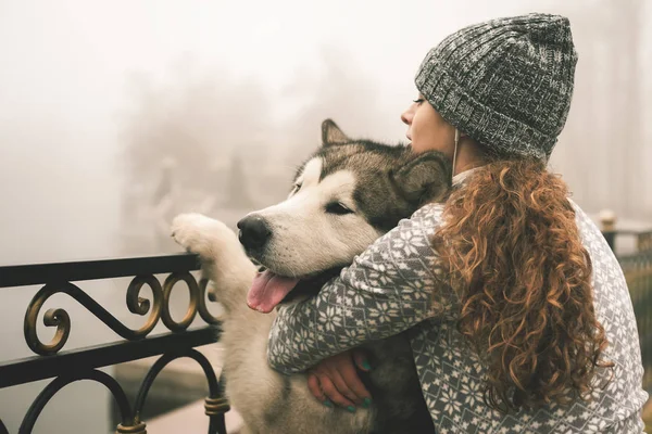 Bilden av ung flicka med hennes hund, alaskan malamute, Utomhus — Stockfoto