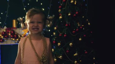Şirin Bebek kız dekore edilmiş Noel ağacı arka plan üzerinde poz