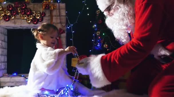 산타는 크리스마스 귀여운 어린 소녀에 게 선물 상자 — 비디오