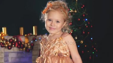 Sevimli küçük kız dans, arka plan süslenmiş Noel ağacı