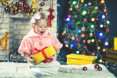 sevimli küçük kız Noel ağacı süsleme yakınındaki bir hediye almak.