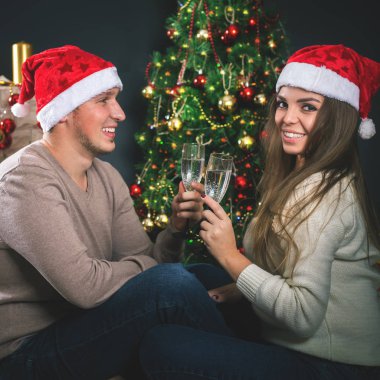 Çift genç yakınındaki bir şekilde dekore edilmiş Noel ağacı yeni yıl kutlama