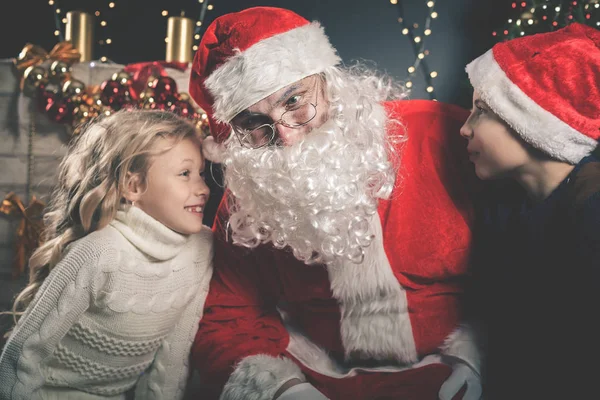 Santa και τα παιδιά γύρω από το στολισμένο χριστουγεννιάτικο δέντρο. Λίστα ευχές — Φωτογραφία Αρχείου