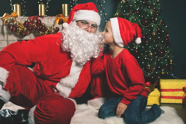 Papai Noel e menino perto da árvore de Natal decorada. Lista de desejos — Fotografia de Stock