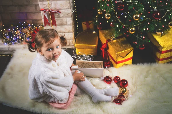Ragazza bambino carino decorare un albero di Natale. Palle rosse . — Foto Stock