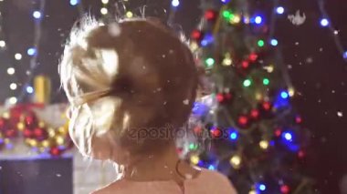 Sevimli küçük kız dans, arka plan süslenmiş Noel ağacı