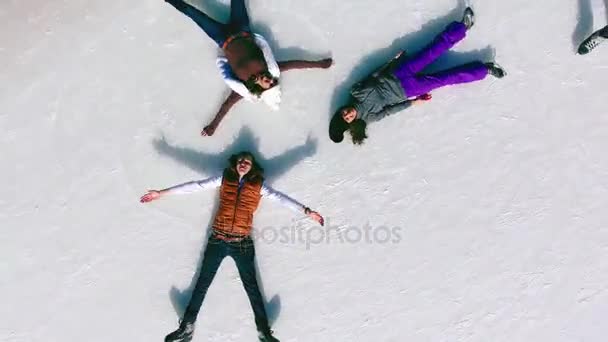 Вид с воздуха катание на коньках людей, делающих каток снежный ангел — стоковое видео