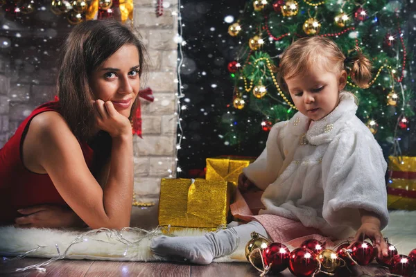 Bambino carino e mamma che decorano un albero di Natale. Palle rosse . — Foto Stock