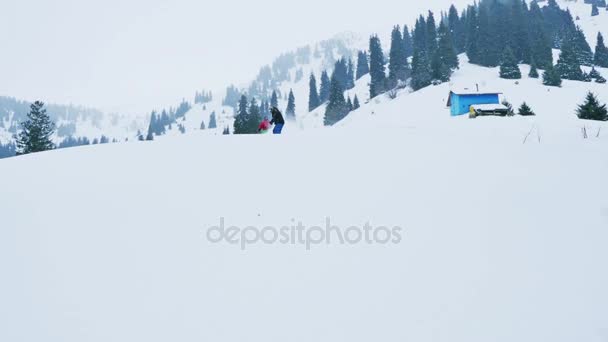 Felvétel, snowboardos és síelő férfi gyors lovaglás a hegyek — Stock videók