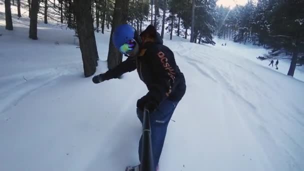 Filmagem em câmera lenta do homem snowboarder cavalgando pela floresta — Vídeo de Stock