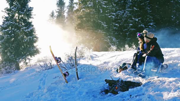 Snowboardzistów para rozgrzać przez góry na zewnątrz, ognisko — Wideo stockowe