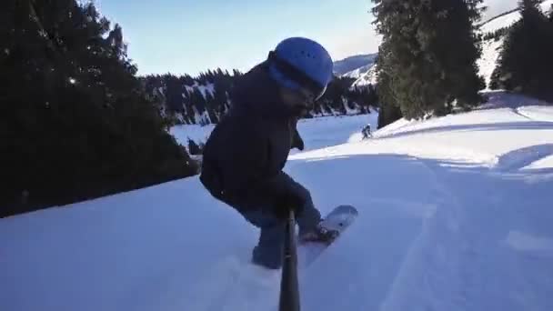 Hombre snowboarder cabalgando en las montañas nevadas de los Alpes — Vídeo de stock