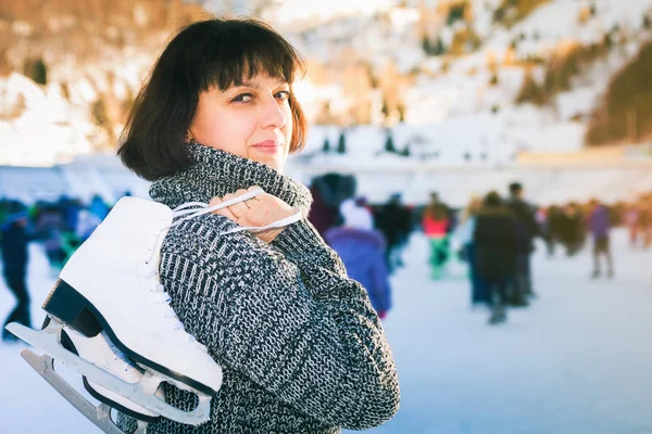 Mujer madura feliz sostiene patines en pista de hielo Medeo —  Fotos de Stock