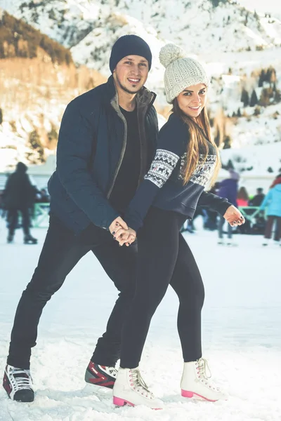 Gelukkige paar, meisjes en jongen schaatsen buiten op ijsbaan — Stockfoto