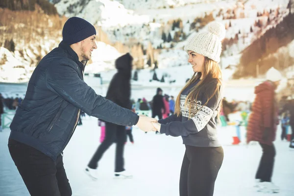 幸せなカップル、女の子と男の子でアイス スケート屋外スケート リンク — ストック写真