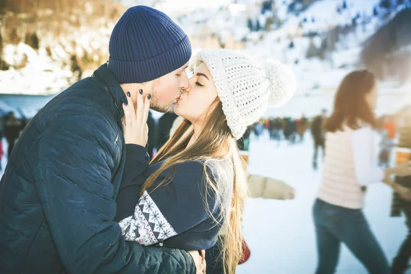 Beijando casal, meninas e menino patinação no gelo ao ar livre no ringue — Fotografia de Stock