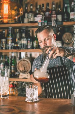 Yakışıklı barmen kokteyl yapıyor