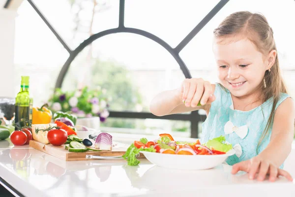 Το χαριτωμένο μικρό κορίτσι κάνει σαλάτα. Παιδί για μαγείρεμα. Υγιεινά τρόφιμα — Φωτογραφία Αρχείου